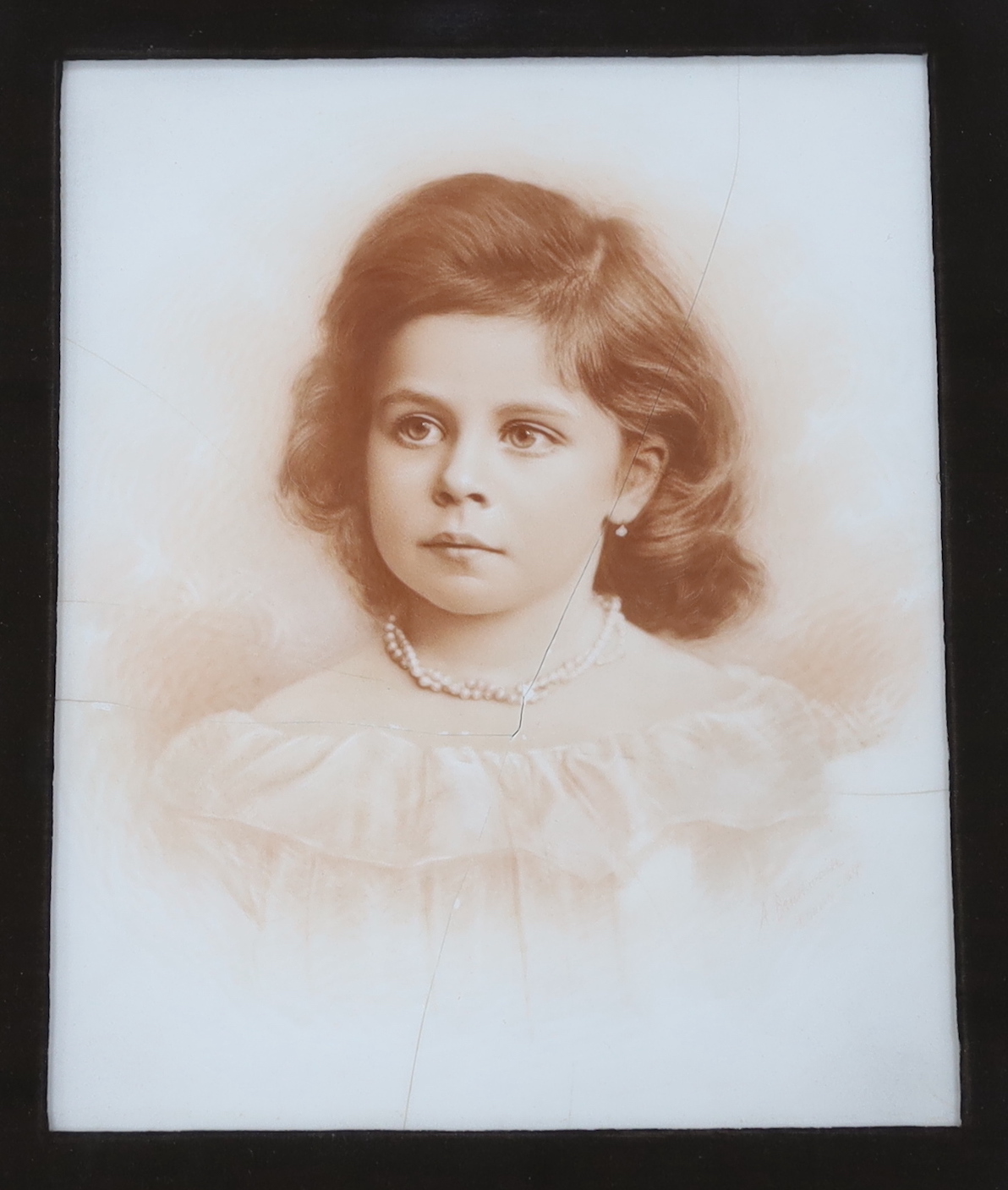 A large photographic print, Infant on rocking horse, housed in a carved frame ‘Russel, 1891’, and another similar framed sepia photograph, largest overall 79 x 79cm